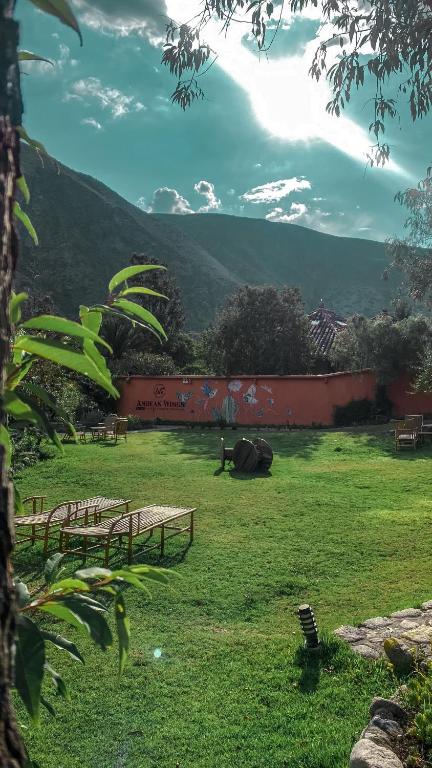 un parco con panchine in un campo con una montagna di Andean Wings Valley a Urubamba