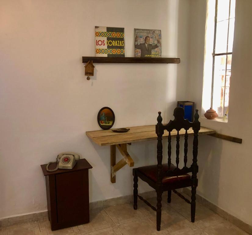 a room with a wooden table and a chair at Llamingo Hostel in Quito