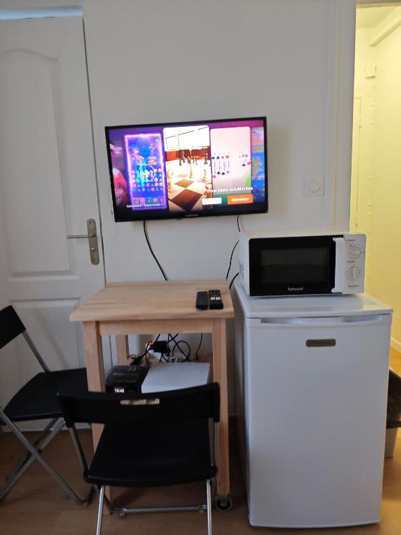 un bureau avec un ordinateur et un moniteur sur un mur dans l'établissement Détente urbaine, à Aubervilliers