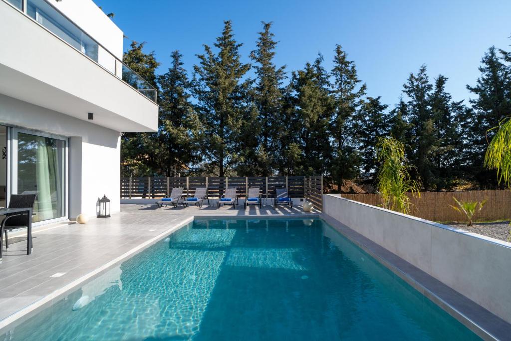 una piscina con sedie accanto a una casa di M&B Luxury Villa a Haraki