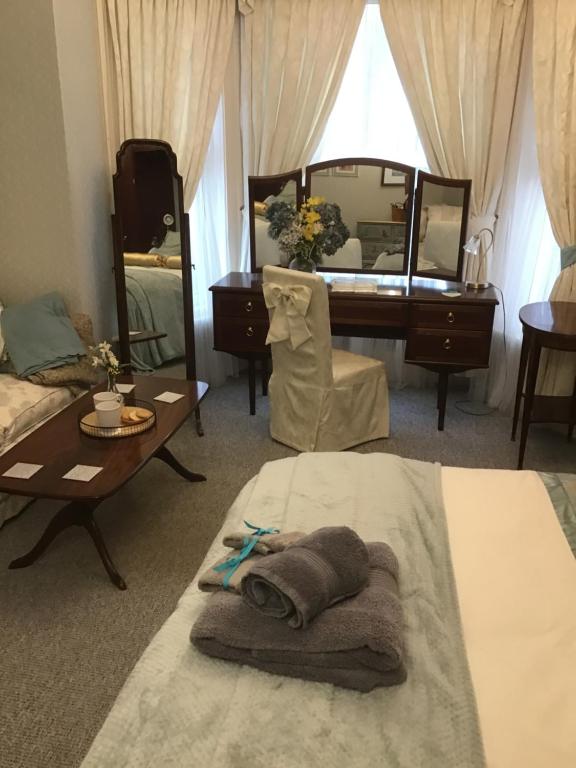 1 dormitorio con 1 cama con mesa y espejo en The Old Merchants House - The Vettriano Room en Southampton