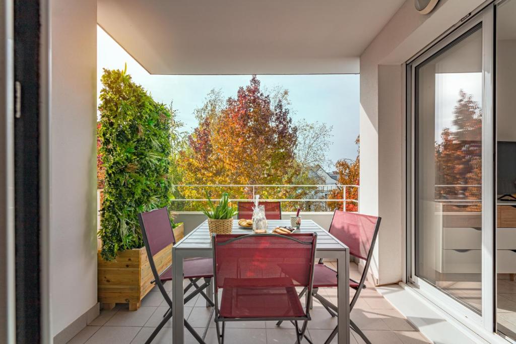 洛里昂的住宿－Appart cosy avec grand balcon et parking privatif，阳台的用餐室配有桌椅