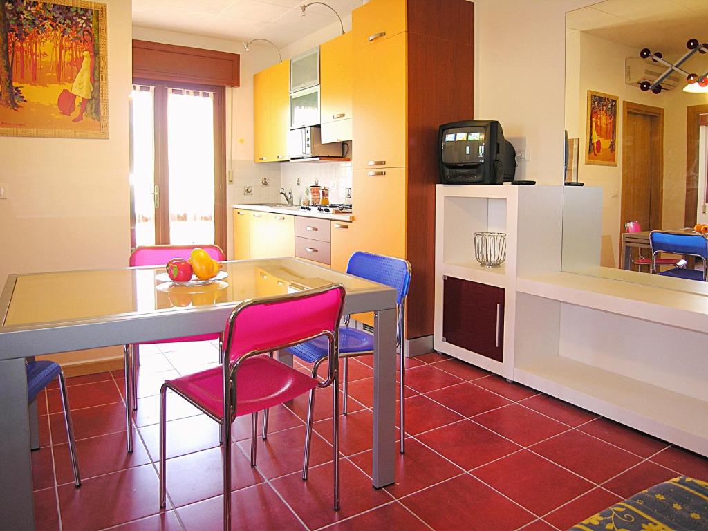 una cucina con tavolo, sedie e bancone di Appartamenti Lira a Bibione