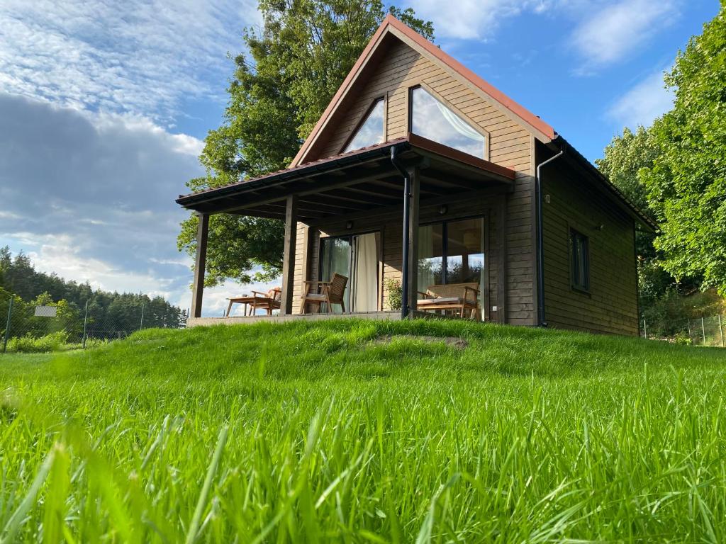 ein Haus auf einem Grashügel in der Unterkunft Stodoła Drwęck 