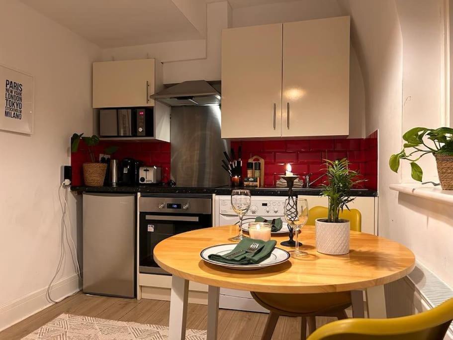 eine kleine Küche mit einem Holztisch in einem Zimmer in der Unterkunft Flat in Victorian West Kensington Mansion in London