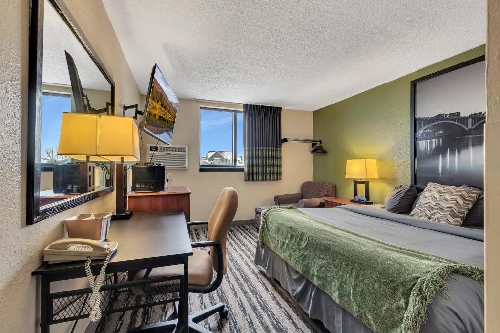 a hotel room with a bed and a desk at Bison Plains Lodge in Moorhead