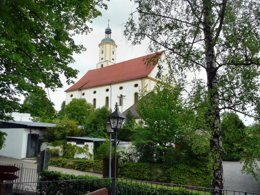 ein Gebäude mit einem Uhrenturm darauf in der Unterkunft Wallfahrtswirt in Wemding