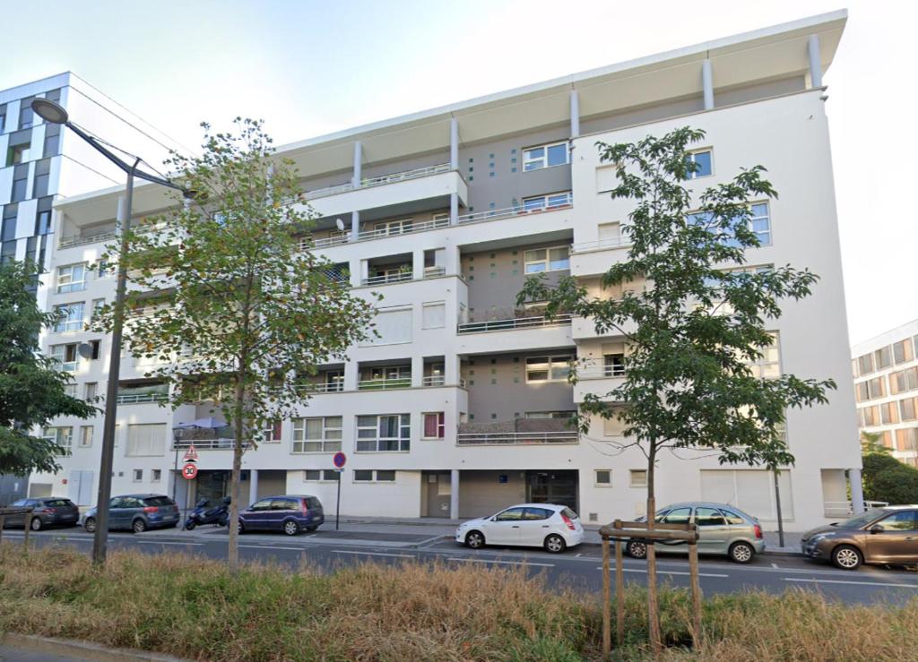 ein Apartmenthaus mit davor geparkt in der Unterkunft Bail mobilité Le Grimaldi in Massy