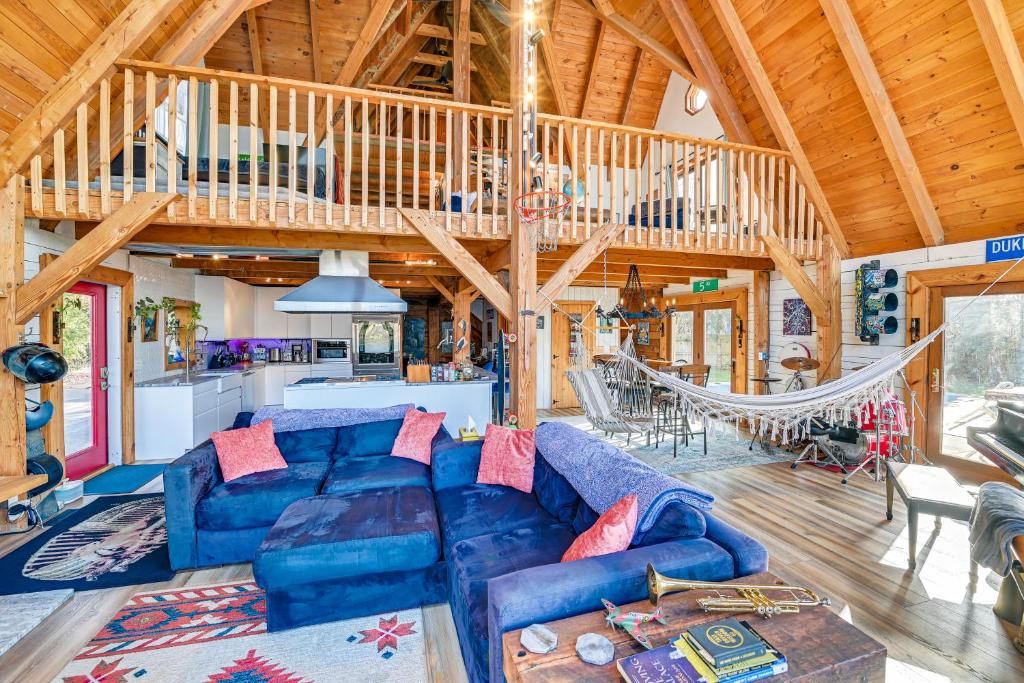 a living room with a blue couch and a wooden ceiling at Riverfront A-Frame Cabin in Troy with Pool and Dock! in Troy