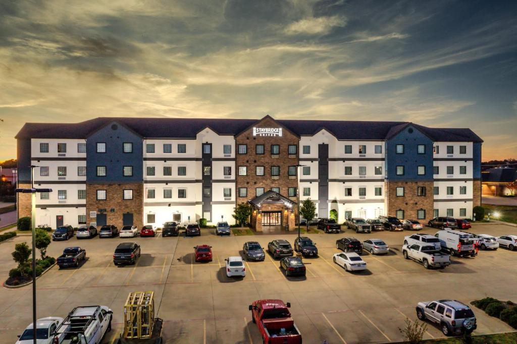 a large building with cars parked in a parking lot at Staybridge Suites Longview, an IHG Hotel in Longview