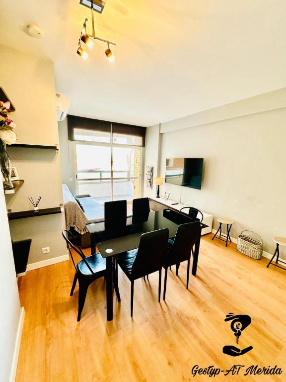 a dining room and living room with a table and chairs at Apartamento Turístico Pizarro in Mérida