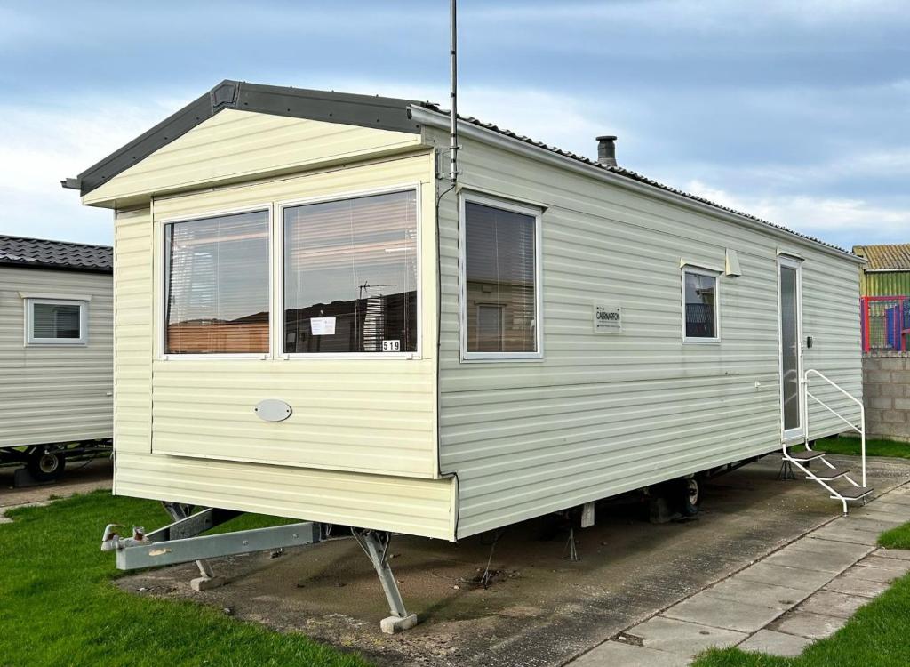 a tiny house is sitting on a trailer at 519 Family Caravan at Golden Gate Holiday Centre, Sleeps 6 in Abergele