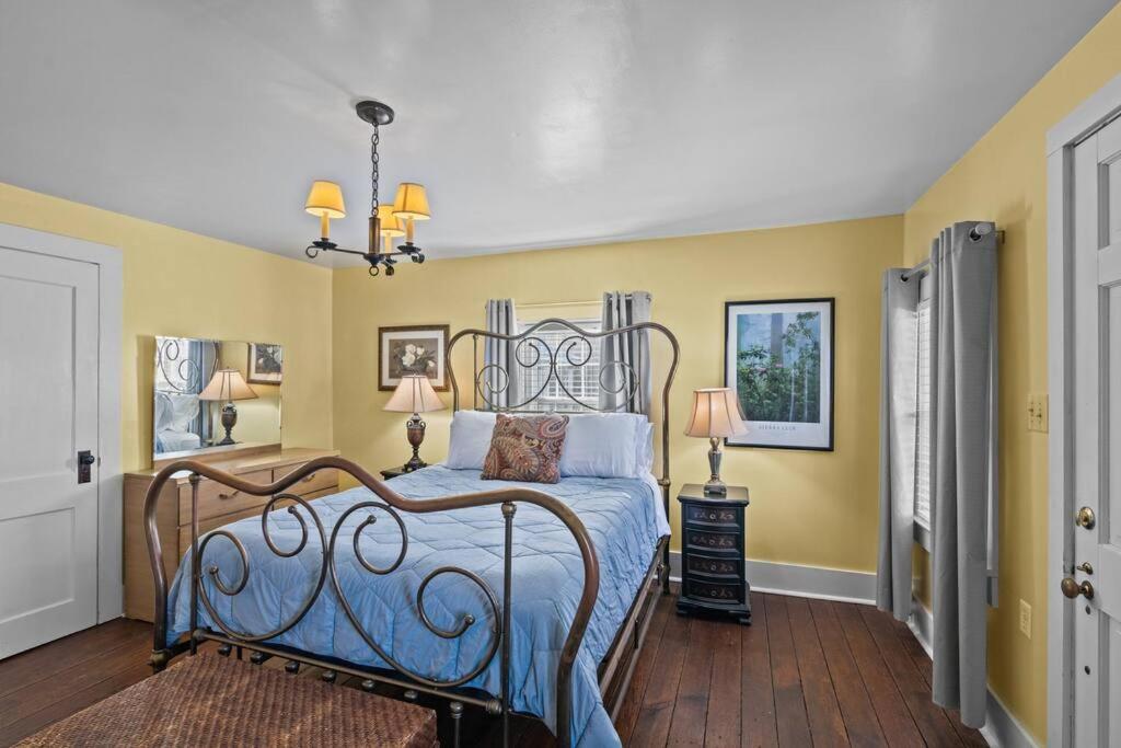 1 dormitorio con 1 cama con paredes amarillas en Historic Hartsfield House, en New Bern