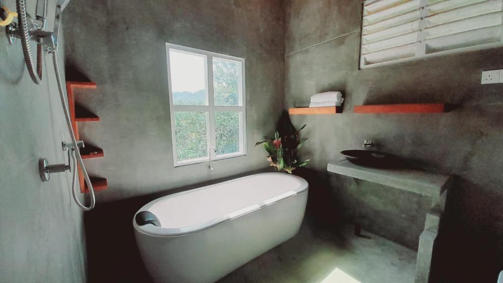 baño con una gran bañera blanca y una ventana en Dins Nature Villa 