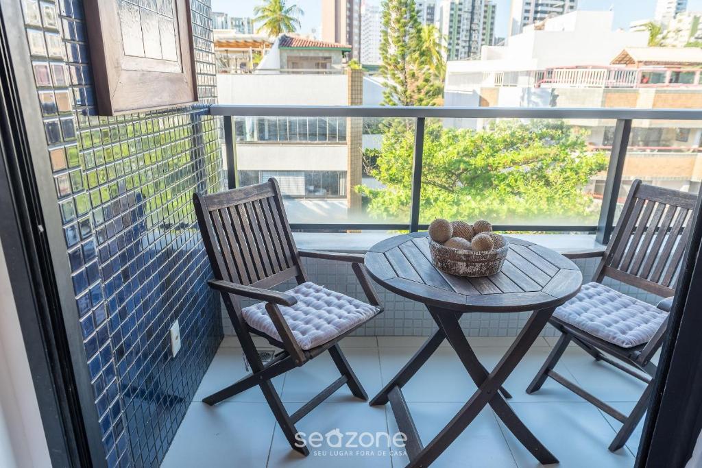 un balcón con 2 sillas y una mesa en el balcón en Apto luxuoso próximo ao mar OCH0511, en Salvador