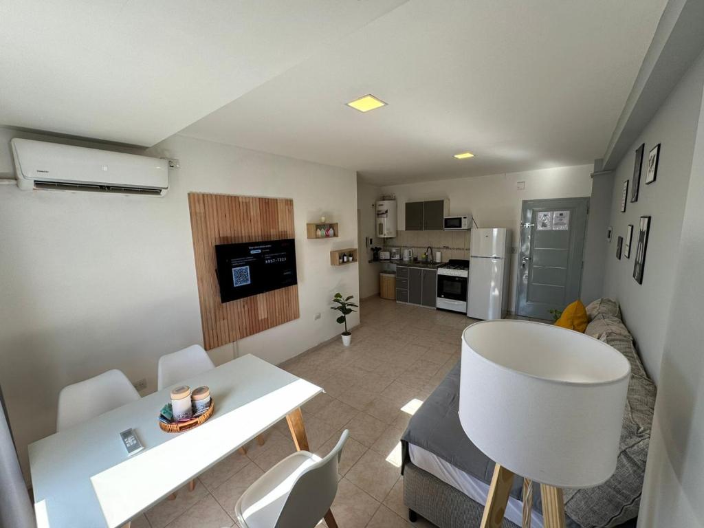 a small living room with a table and a kitchen at Solar Suites in Neuquén