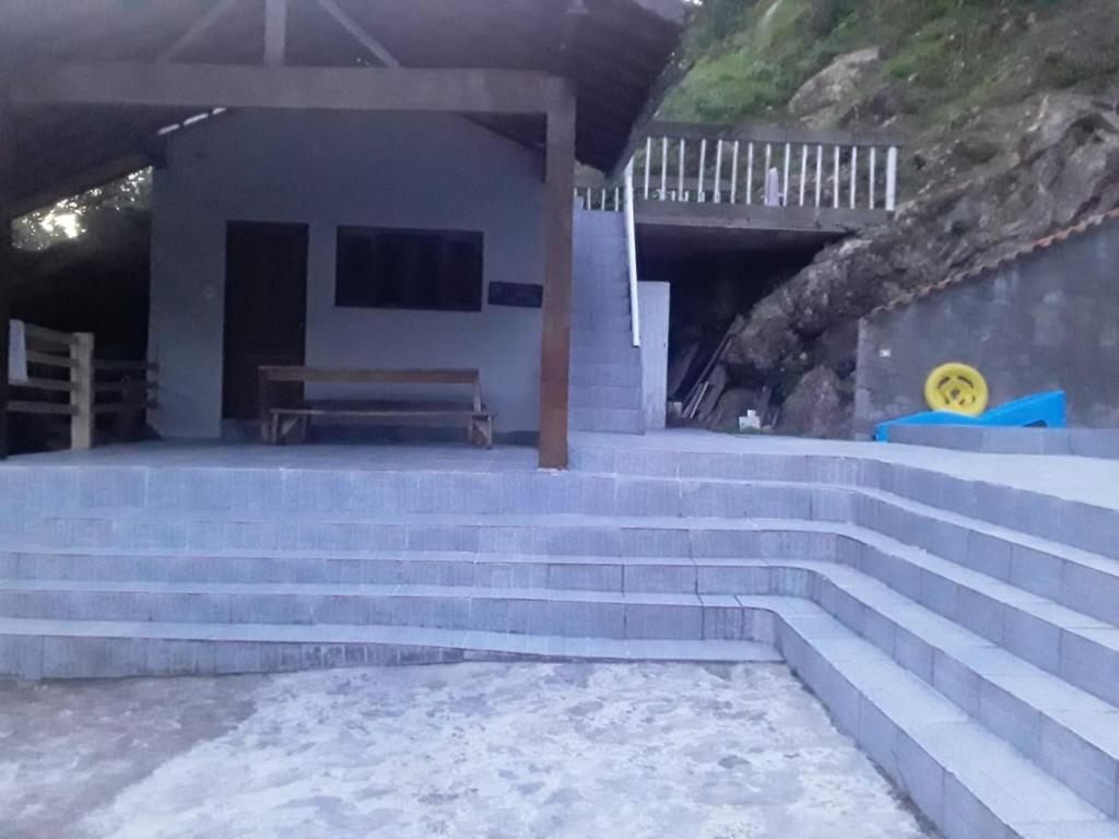 un escalier en face d'un bâtiment avec un banc dans l'établissement Pousada do Toninho, à Peruíbe