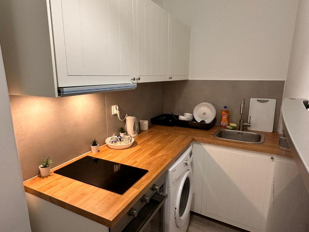 a kitchen with white cabinets and a sink and a dishwasher at Rynek 6 in Poznań