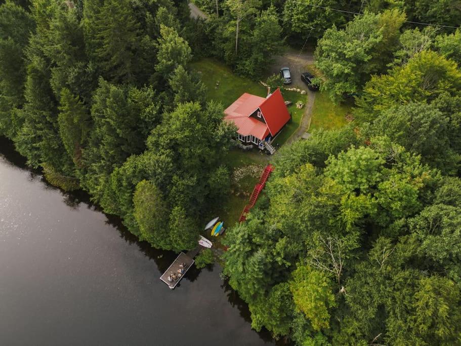 eine Luftansicht eines Hauses im Wald neben einem Fluss in der Unterkunft Chalet unique et chaleureux en pleine nature in Shawinigan