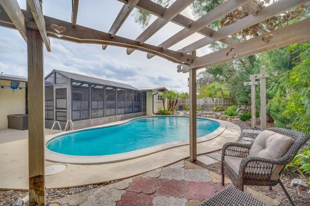 a swimming pool with a pergola next to a house at Centrally Located Merritt Island Home Pool, Porch in Merritt Island