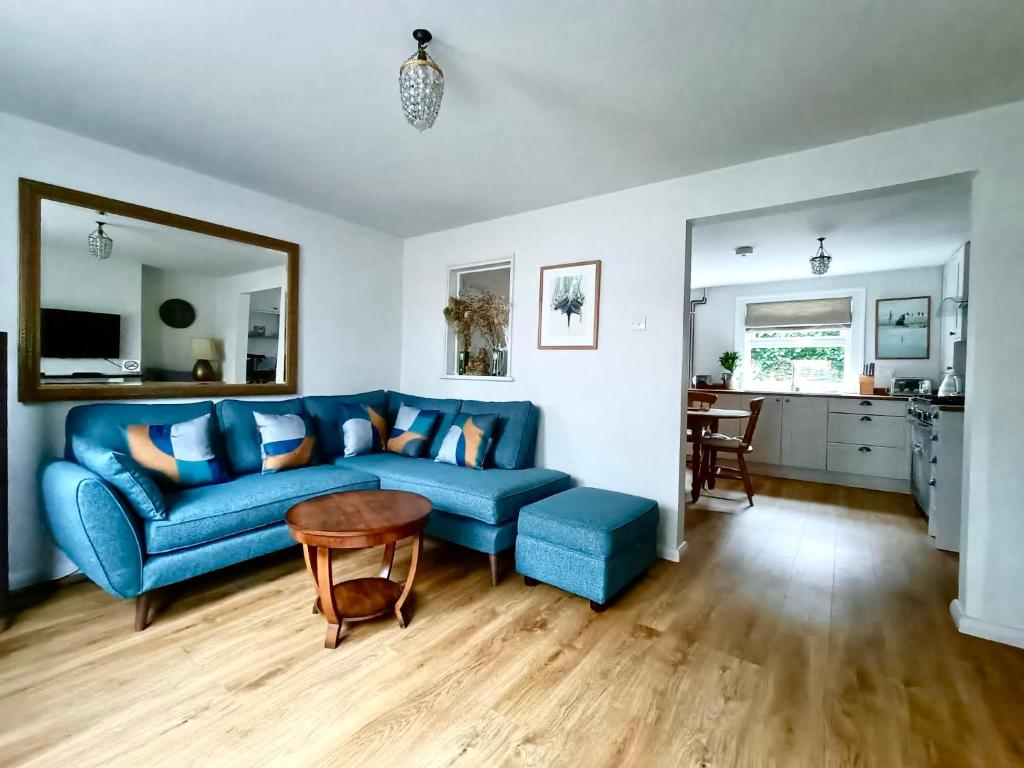 a living room with a blue couch and a table at Welcoming 2 bed townhouse near town centre & beach in Kent