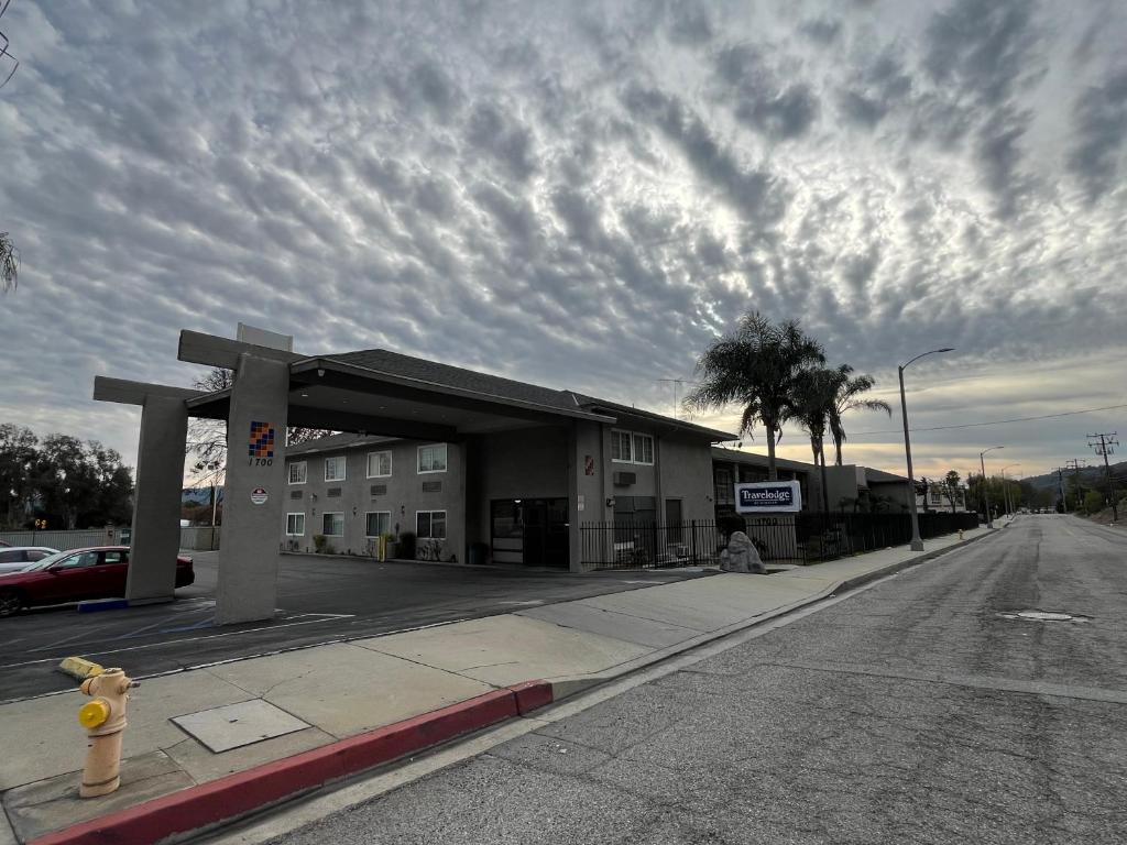 a building on the side of a street with a fire hydrant at Travelodge by Wyndham Fairplex Pomona in Pomona