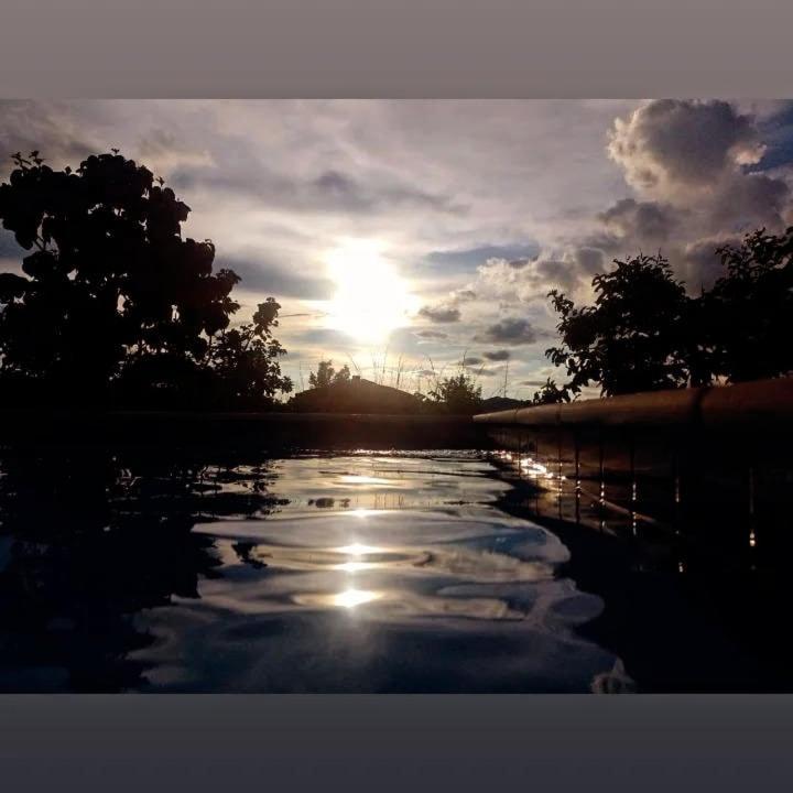 un tramonto su un corpo d'acqua con il sole di Chácara Recanto das flôr a Pirenópolis
