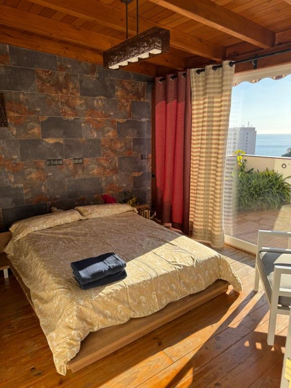 sypialnia z łóżkiem i kamienną ścianą w obiekcie Duplex de lujo en la playa , jacuzzy, piscina, chimenea y padel w mieście Benalmádena