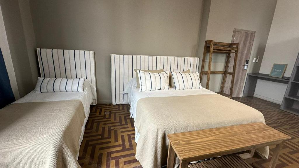薩爾塔的住宿－Hostel New Time，一间设有两张床和一张桌子的房间