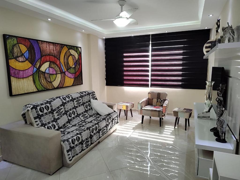 a living room with a couch and a table at Apartamento a 100 metros da Praia do Forte - Algodoal 206 in Cabo Frio