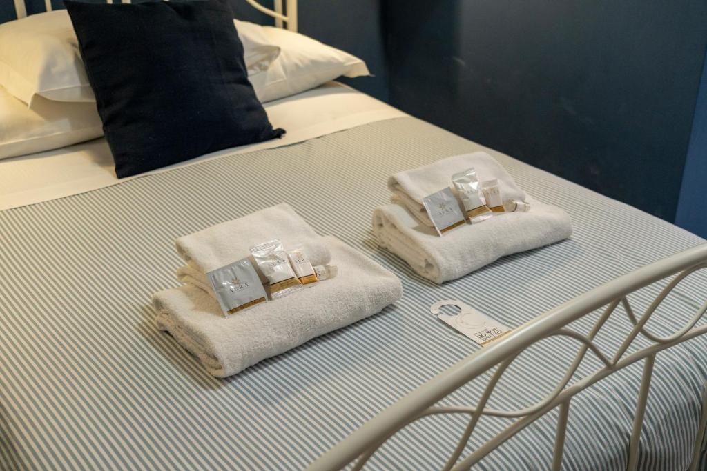 Una cama con toallas encima. en San Pietro Roma Suite en Roma