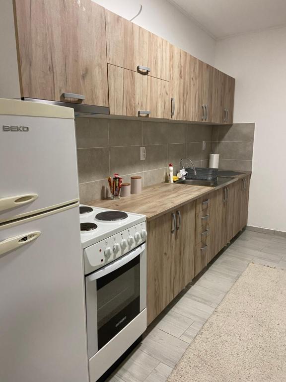 a kitchen with a stove and a white refrigerator at Kula Dream apartment in Kula