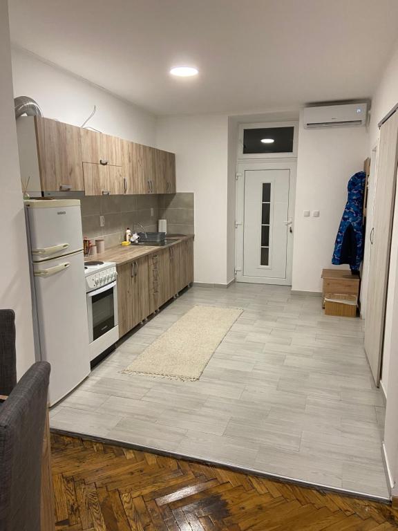 a kitchen with white appliances and wooden cabinets at Kula Dream apartment in Kula