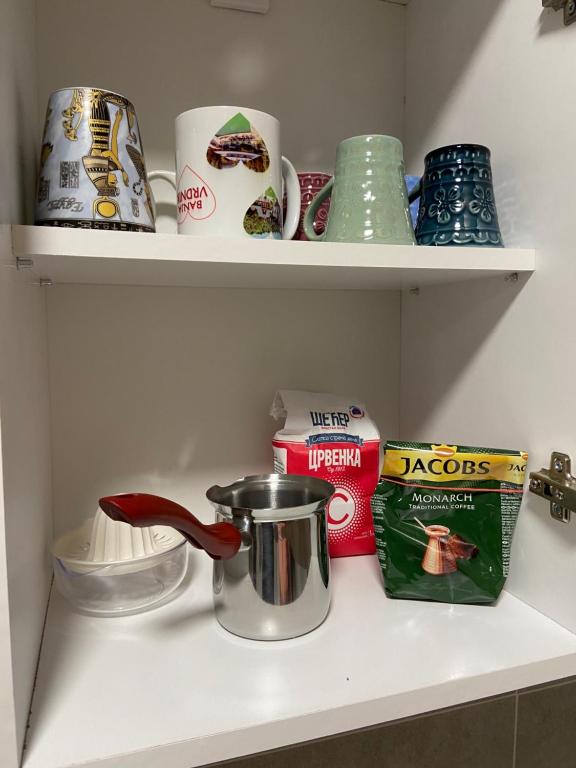 a kitchen shelf with a tea pot and other items at Kula Dream apartment in Kula