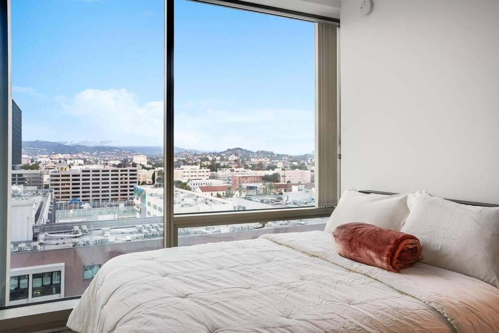 a bed in a room with a large window at NEW 1BR Luxury Highrise in Los Angeles