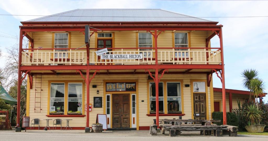 a wooden building with a balcony and a table at Formerly the Blackball Hilton in Blackball