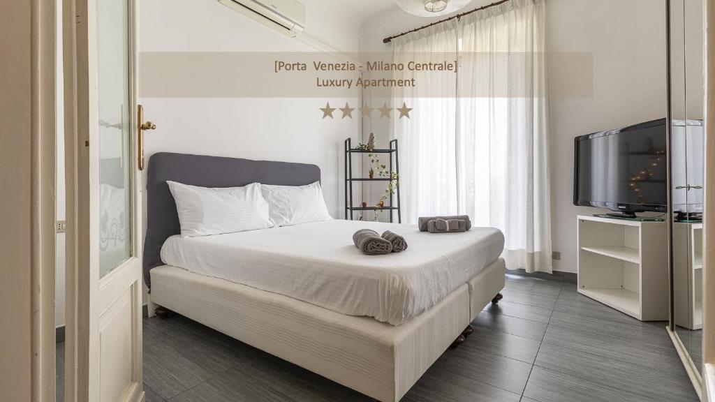 ein Schlafzimmer mit einem Bett mit zwei Hausschuhen darauf in der Unterkunft [Porta-Venezia/Milano Centrale]Luxury Apartment in Mailand