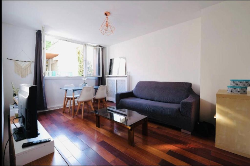 ein Wohnzimmer mit einem Sofa und einem Tisch in der Unterkunft Lovely spacious nest in Ivry in Ivry-sur-Seine