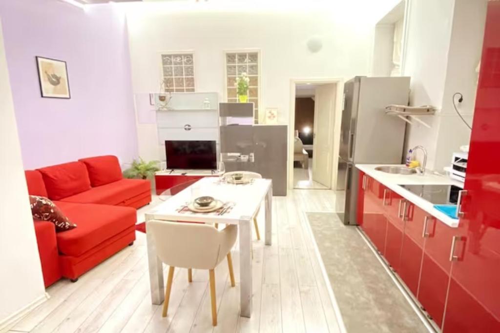 een woonkamer met een rode bank en een witte tafel bij Yes, yes! lovely apartment good amenities Budapest center in Boedapest