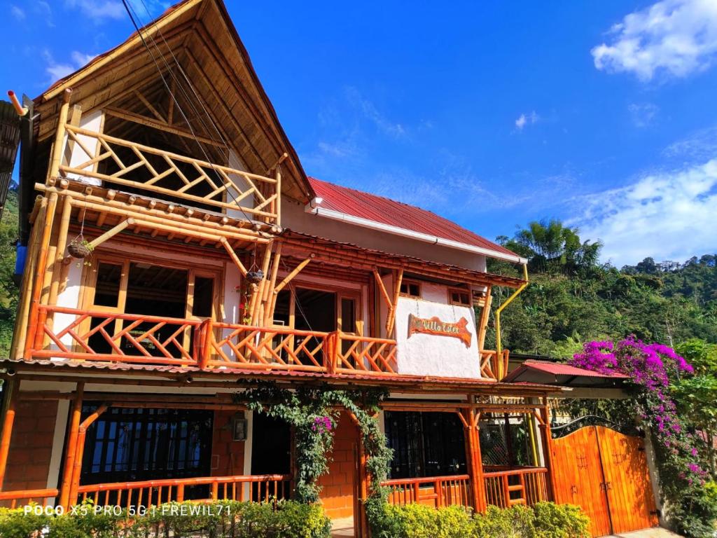 a wooden house with a balcony on top of it at Villa Ester Hostel Vereda Cay in Ibagué