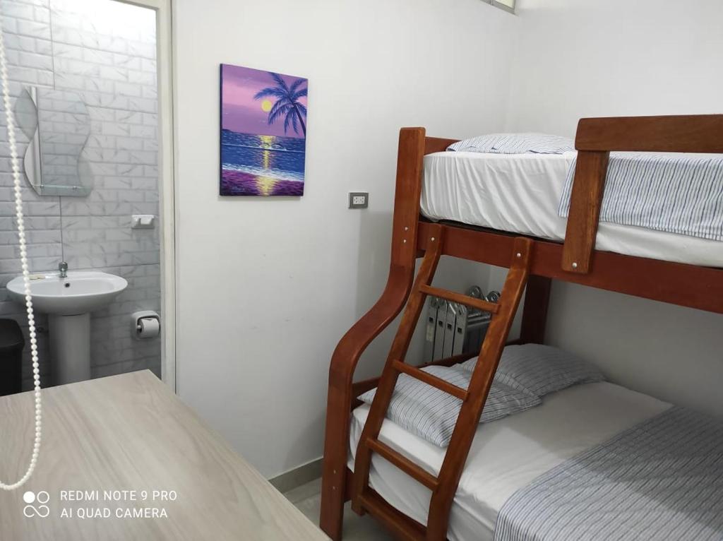 una camera con 2 letti a castello e un lavandino di La Silvita - Casa de playa a Los Órganos