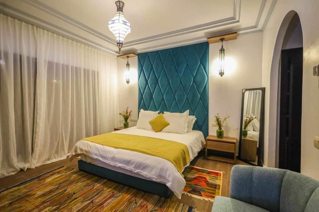 een slaapkamer met een groot bed en een blauwe muur bij Dar Nia in Marrakesh