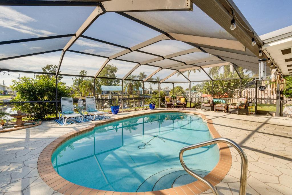 una piscina con sombrilla y sillas alrededor en Port Charlotte Paradise with Private Outdoor Oasis!, en Port Charlotte