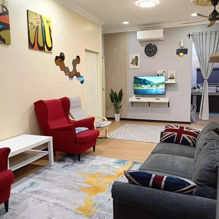 een woonkamer met een bank, 2 stoelen en een tv bij DH Merlimau Homestay in Merlimau