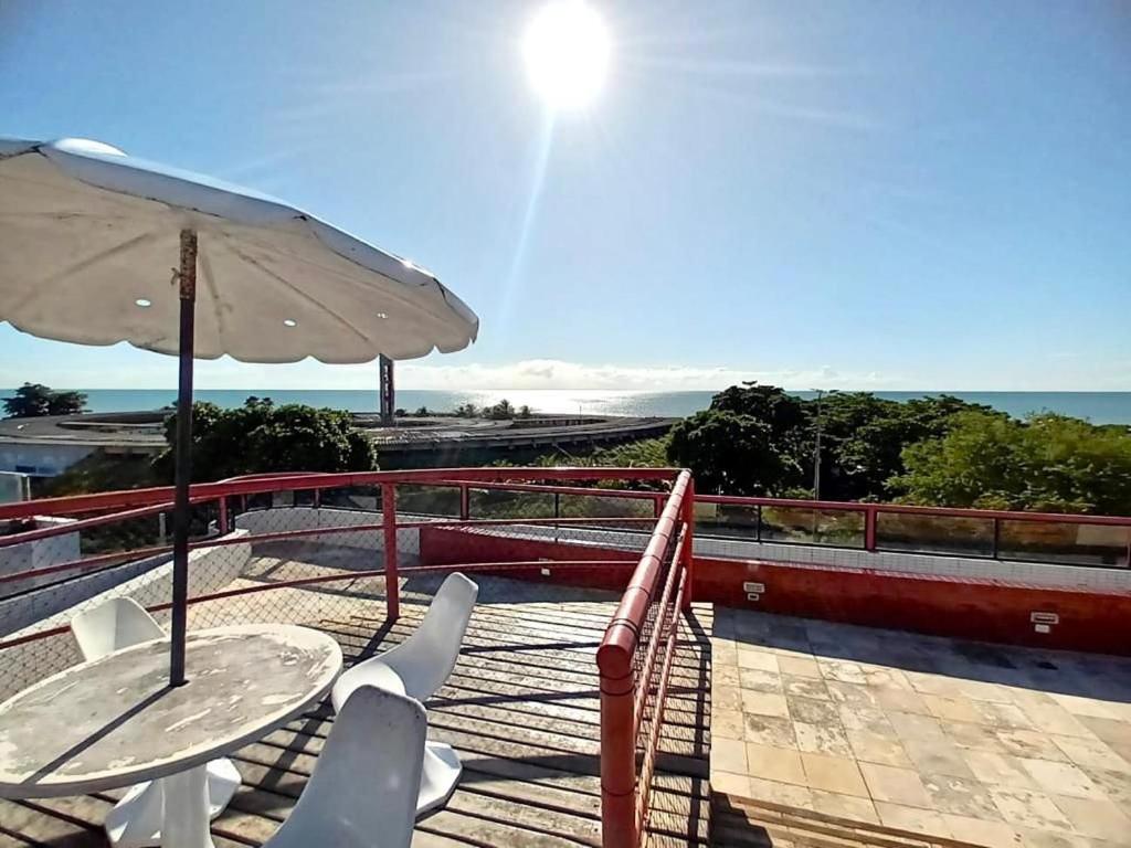 a patio with two tables and an umbrella at Victory Flat in João Pessoa