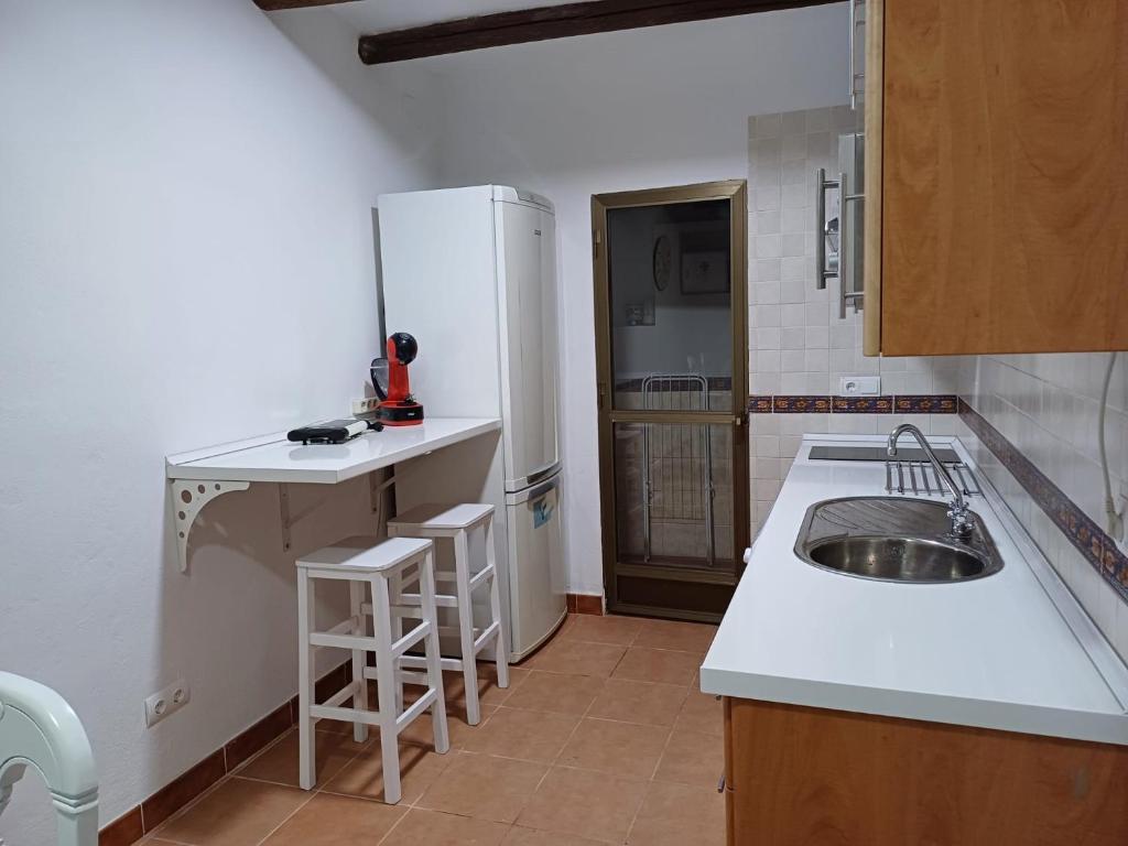 a kitchen with a sink and a white refrigerator at La casita Ronda in Ronda
