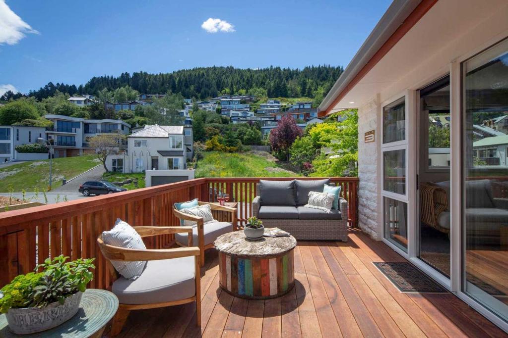 a porch with a couch and a table on a balcony at Hillside Villa 3- Walk To Town- AC- Free Parking in Queenstown