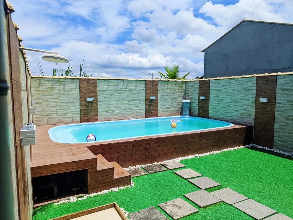 una gran piscina en un patio trasero con césped verde en Suncoast House, en Cabo Frío