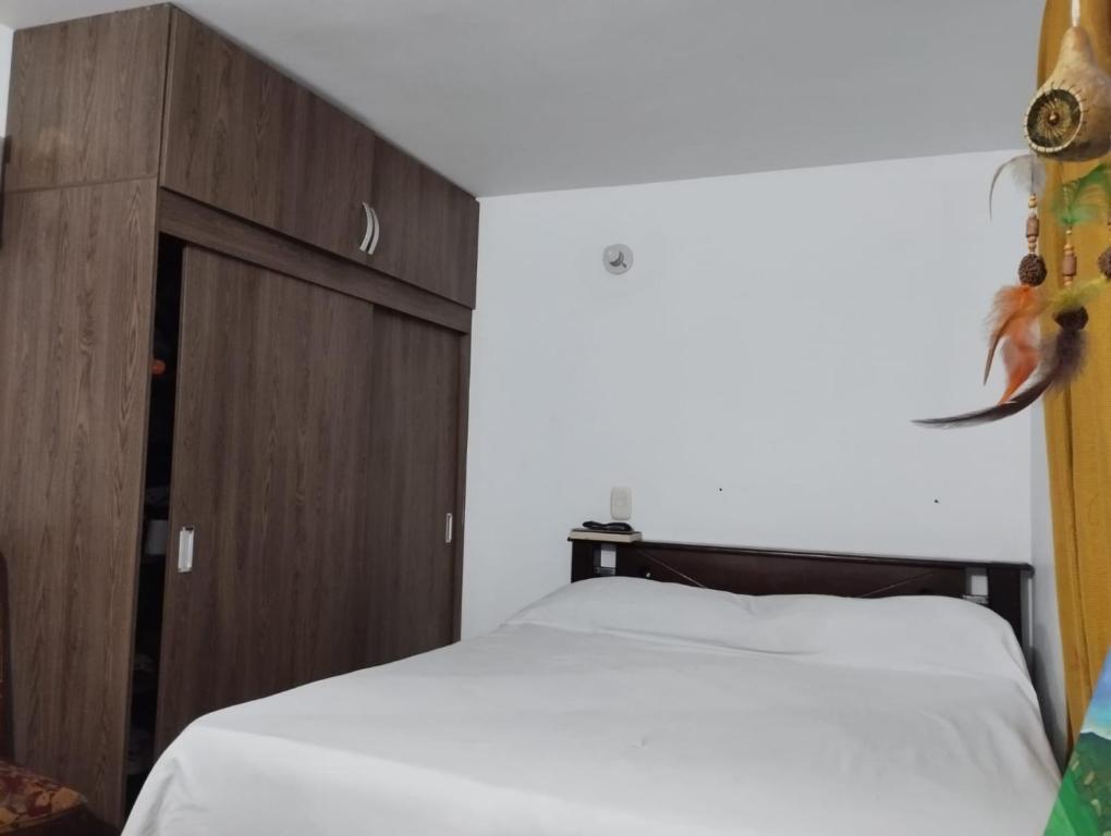 1 dormitorio con 1 cama y armario de madera en Welcome to Medellin in our home, en Medellín