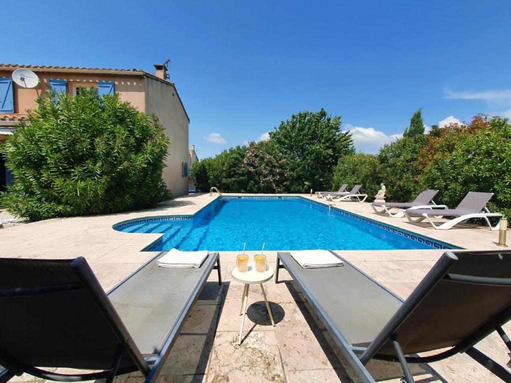 a swimming pool with two chairs and a swimming pool at Roco Aigle 